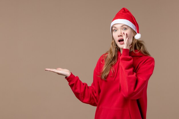 正面図のクリスマスの女の子が茶色の背景に新しい年のクリスマス休暇を呼び出す