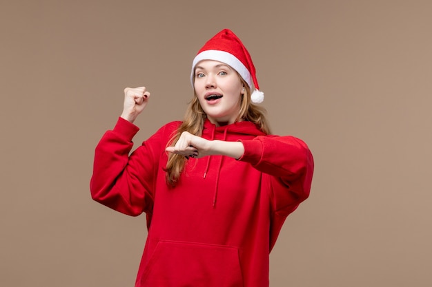 正面図クリスマスの女の子茶色の背景の休日のクリスマスの感情の時間をチェック