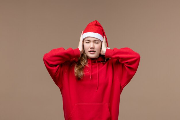 Front view christmas girl covering her ears on brown background holiday christmas emotion