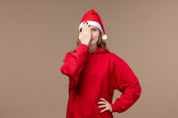 Front view christmas girl covering her face on a brown background model holiday christmas