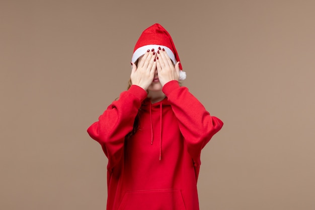 Вид спереди рождественская девушка закрыла лицо на коричневом фоне модель праздник рождество