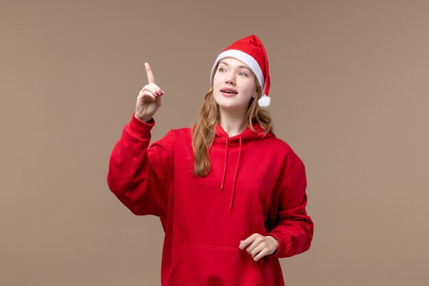 Front view christmas girl pointing on brown background holidays new year christmas