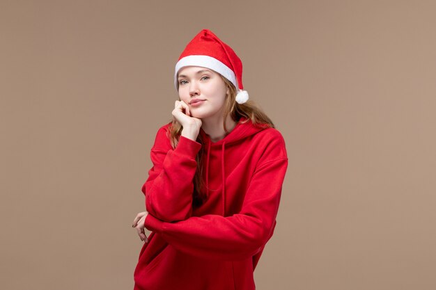 Front view christmas girl posing with red cape on brown background model holiday christmas