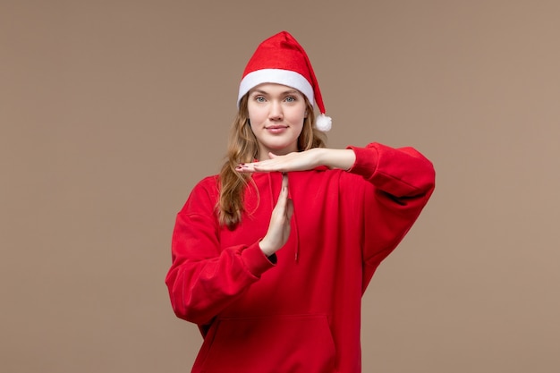 Вид спереди рождественская девушка позирует с улыбкой на коричневом фоне праздник рождественские эмоции