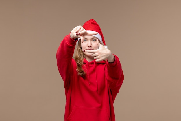 Foto gratuita ragazza di natale di vista frontale che posa con il sorriso sull'emozione marrone di natale di festa del fondo