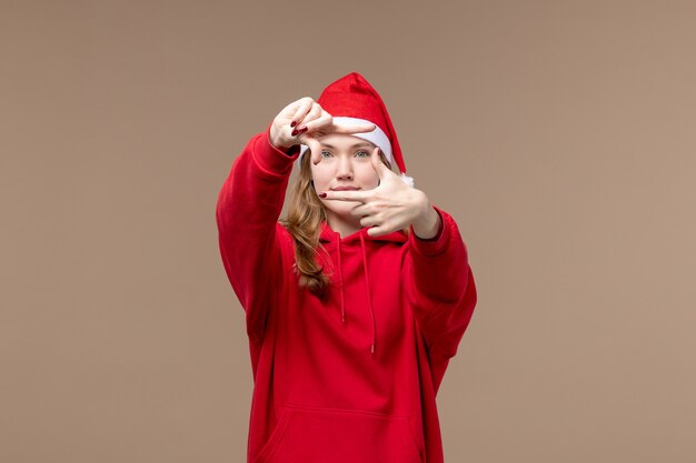 Front view christmas girl posing with smile on the brown background holiday christmas emotion