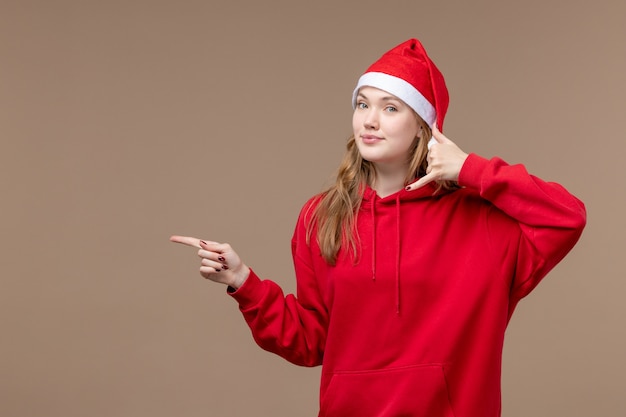 Вид спереди рождественская девушка улыбается на коричневом фоне женщина праздник рождественские эмоции