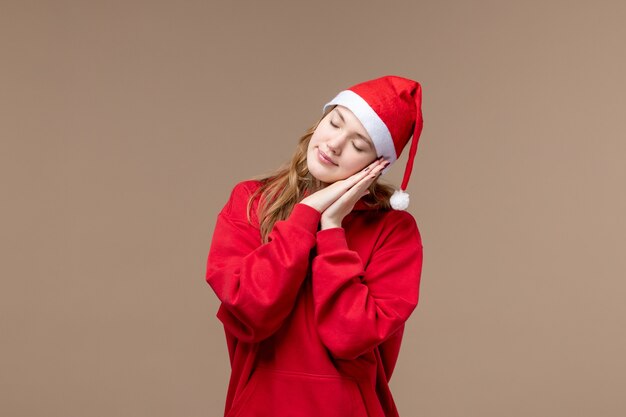 Front view christmas girl trying to sleep on brown background holiday christmas emotion