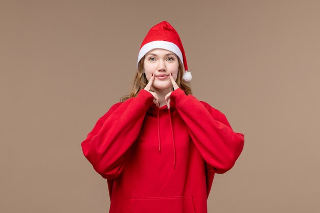 Front view christmas girl trying to smile on a brown background model holiday christmas