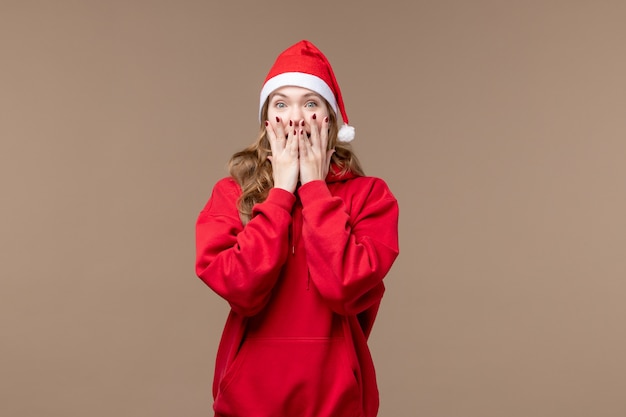 Front view christmas girl with excited face on a brown background holiday new year christmas