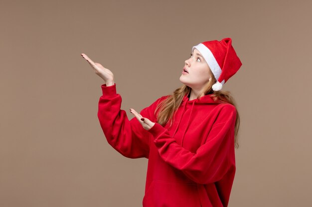 Вид спереди рождественская девушка с нервным лицом на коричневом пространстве