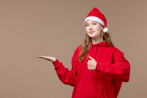 Front view christmas girl with red cape on the brown space