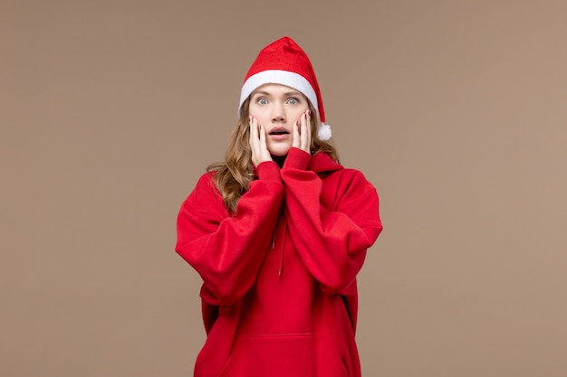 Ragazza di natale di vista frontale con la faccia sconvolta sullo spazio marrone