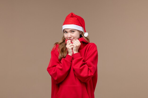 Вид спереди рождественская девушка с улыбающимся лицом на коричневом фоне женщина праздник рождество