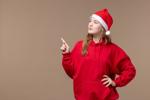 Front view christmas girl with thinking face on brown background holiday new year christmas