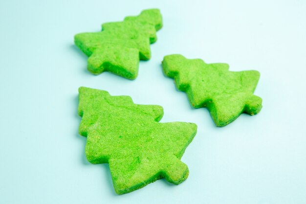 Front view christmas tree cakes on a blue table