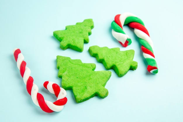 Free photo front view christmas tree cakes with marmalade on blue table