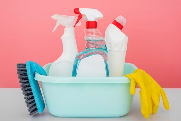 Front view of cleaning solutions in bucket with glove and brush