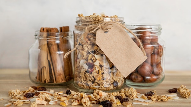 Free photo front view of clear jars with breakfast cereals and tag