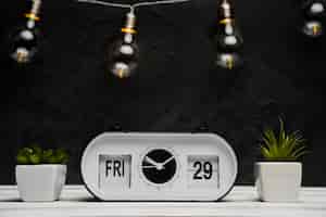 Foto gratuita vista frontale dell'orologio e delle lampadine con la tavola di legno