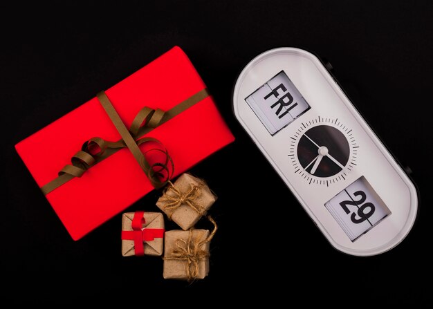 Front view of clock and present on black background