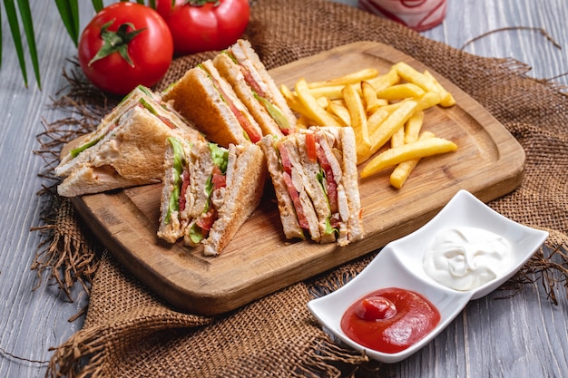 Front view club sandwich with french fries ketchup with mayonnaise and tomatoes