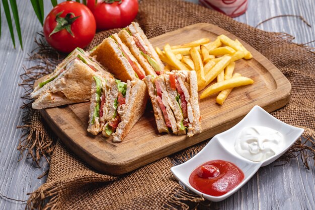 Front view club sandwich with french fries ketchup with mayonnaise and tomatoes