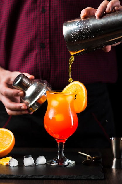 Front view of cocktail being poured in glass