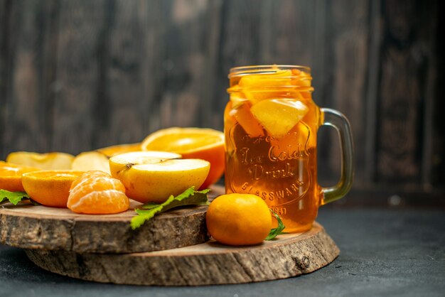 Front view cocktail cut oranges apples on dark background