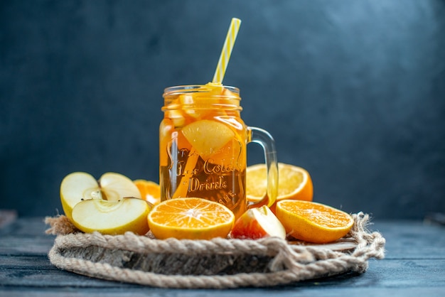 Front view cocktail cut oranges and apples on wood board on dark isolated background