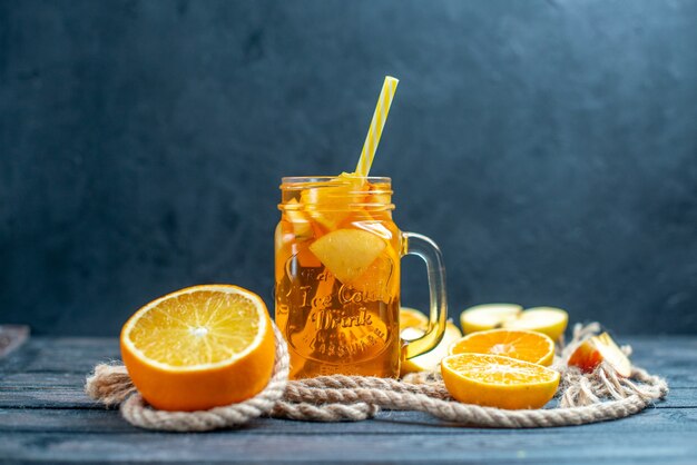 Front view cocktail cut oranges and apples on wood board on dark isolated background