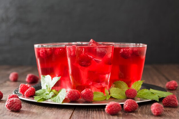 Front view of cocktail glasses with mint and raspberries