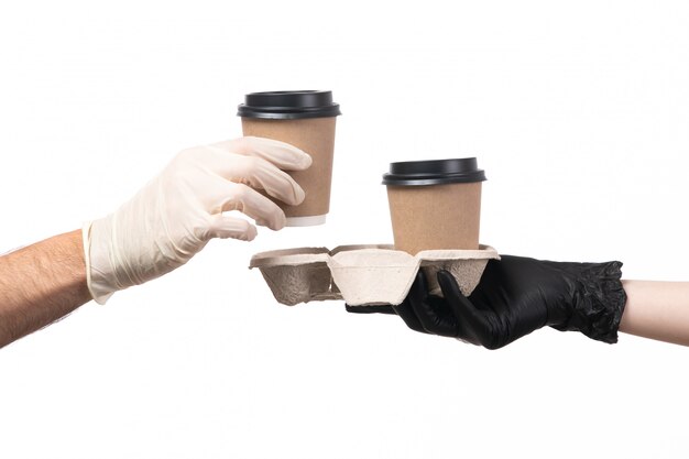 Foto gratuita una vista frontale tazze di caffè offrendo da femmina a maschio