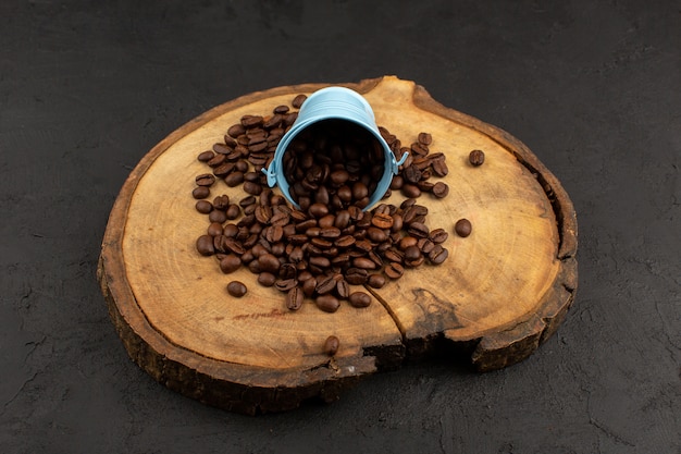 Free photo front view coffee seeds brown whole fresh on the brown desk and dark floor