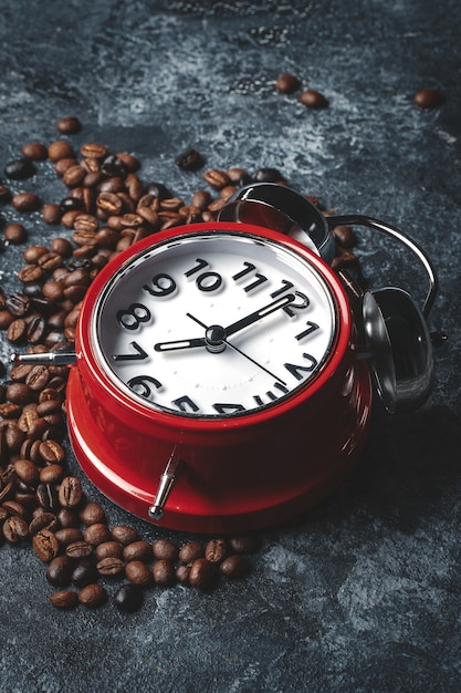 暗い表面に時計が付いているコーヒーの種の正面図