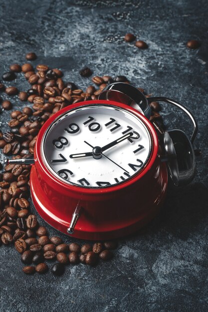 Front view of coffee seeds with clocks on dark surface