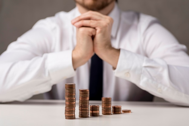 Free photo front view of coins in front of businessman