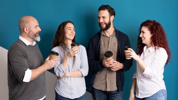 Front view colleagues having coffee together