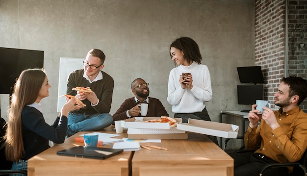 Free photo front view of colleagues having pizza during an office meeting break