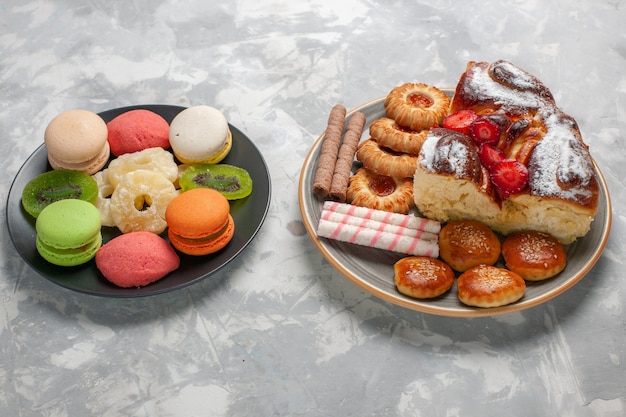 Front view colored little cakes with dried pineapple rings on light white surface