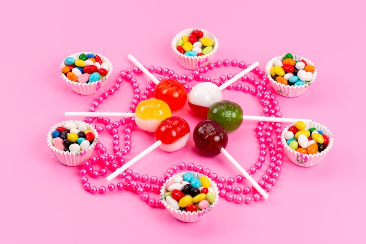Free Photo a front view colorful candies along with lollipops isolated on pink, sweet sugar color