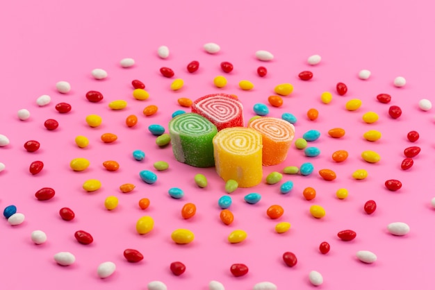 Free photo a front view colorful candies and marmalades isolated on pink, color sugar sweet