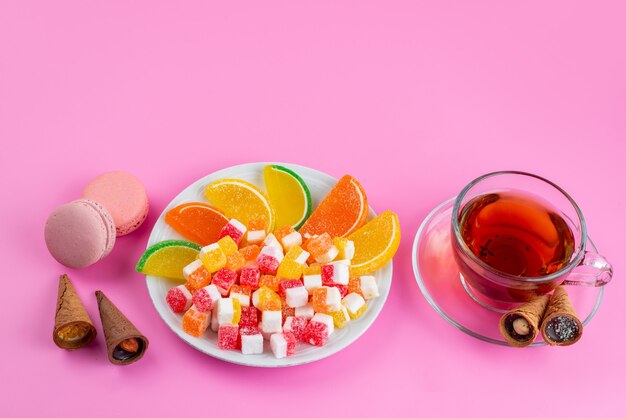 Вид спереди красочные конфеты и мармелад для чаепития на розовом, чайный конфитюр сладкий сахар