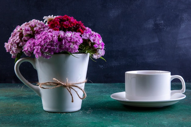 ソーサーにお茶を一杯と白いカップで正面のカラフルな花