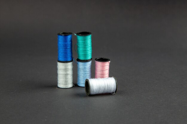 front view colorful threads on dark surface darkness pin sewing measure photo color