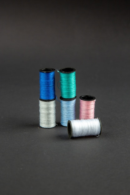 front view colorful threads on dark surface darkness pin sewing measure photo colors