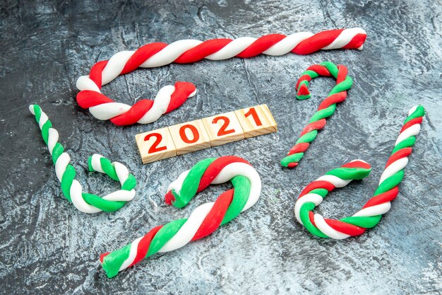 Front view colorful xmas candies wood block on grey background new year photo