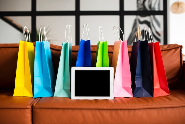 Front view of colourful paper bags and tablet