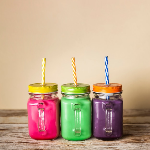 Front view colourful smoothies in jars