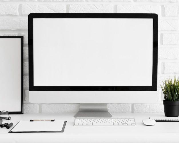 Вид спереди экрана компьютера на рабочем месте офиса с клавиатурой и буфером обмена